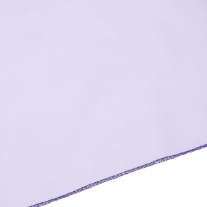 Zbliżenie na krawędź fioletowej organzy z ozdobnym obszyciem. Materiał jest giętki, lekki i łatwy do formowania w dekoracyjne kokardy lub draperie.
