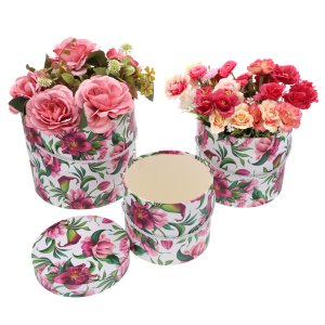 Widok na trzy flower boxy z nadrukiem w kwiaty, dwa z nich są wypełnione kompozycjami kwiatowymi, a jedno jest puste z widoczną pokrywką obok.