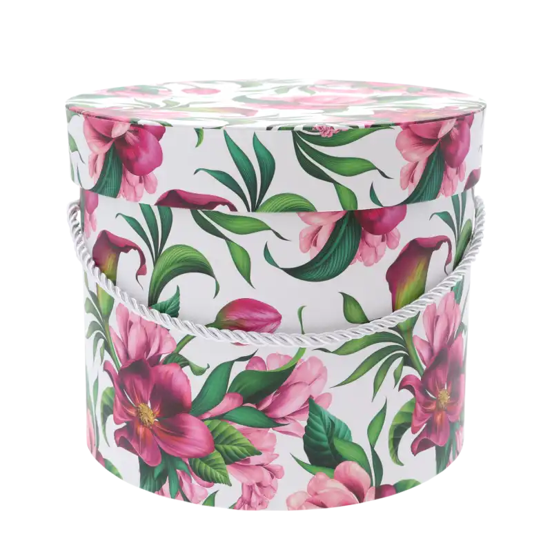 Zbliżenie na pojedynczy okrągły flower box z nadrukiem w kwiaty, wyposażony w ozdobny jasny sznurek pełniący funkcję uchwytu.
