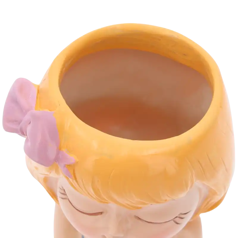 Zbliżenie na otwór ceramicznej osłonki w kształcie dziewczynki, ukazujące głębokość naczynia.