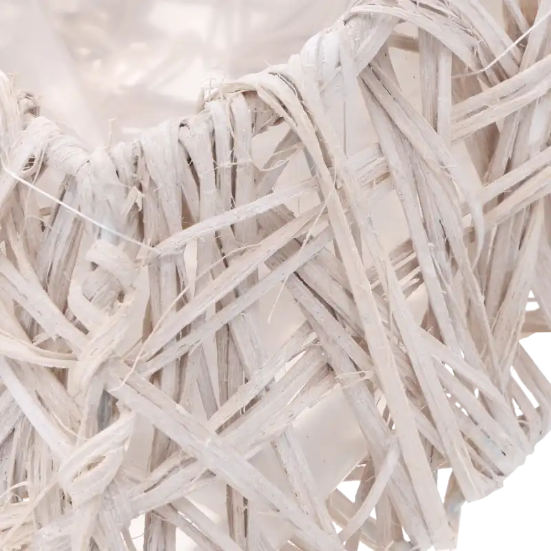 Fragment plecionki rattanowej w odcieniu bieli, ukazujący strukturę naturalnego materiału w dużym przybliżeniu.