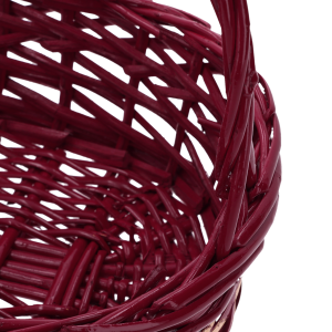 Fragment bordowego kosza wiklinowego z wyraźnie zaznaczonym splotem oraz widocznym łączeniem pałąka z korpusem.