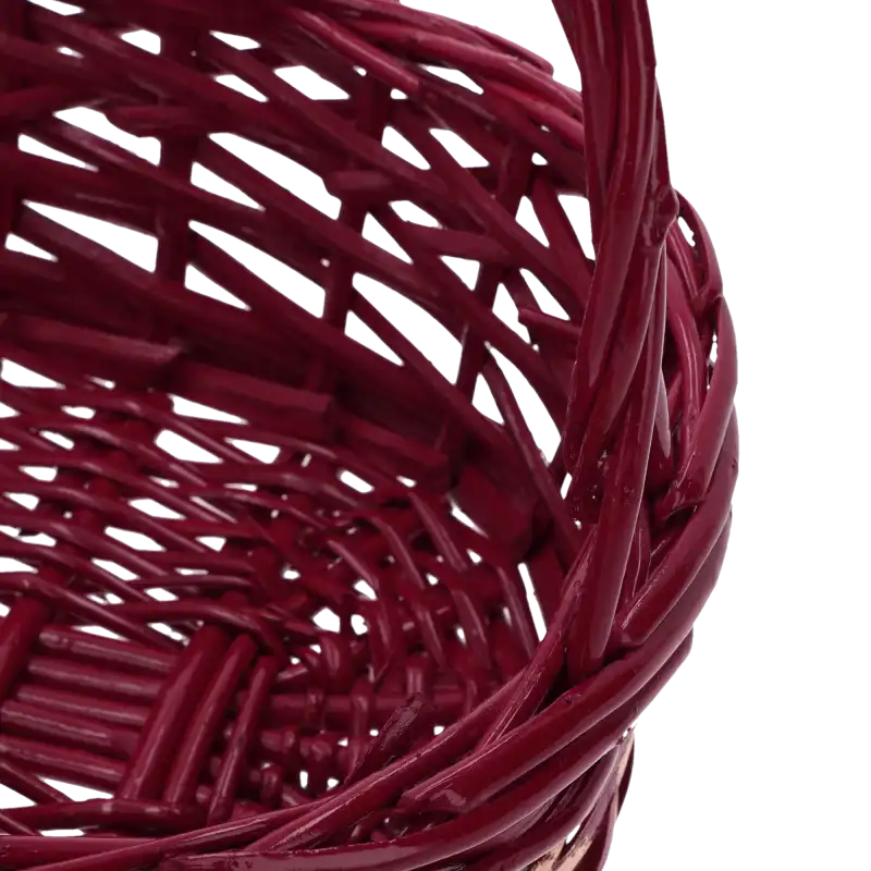 Fragment bordowego kosza wiklinowego z wyraźnie zaznaczonym splotem oraz widocznym łączeniem pałąka z korpusem.