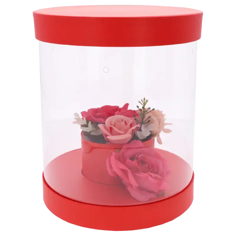 Czerwony flower box z przykładową kompozycją kwiatową wewnątrz. Przezroczyste ścianki eksponują rośliny, zapewniając jednocześnie dostęp powietrza.