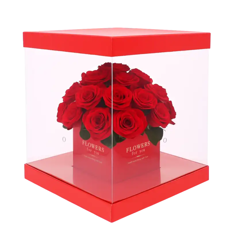 Czerwony kwadratowy flower box 25x25 cm wypełniony żywymi różami. Przezroczyste boki pozwalają wyeksponować rośliny, a dyskretne otwory zapewniają im dostęp do powietrza.