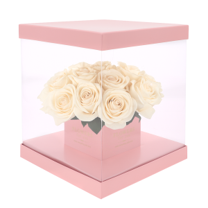 Różowy kwadratowy flower box 25x25 cm z przezroczystymi ściankami wypełniony jasnymi różami. Idealny do efektownej ekspozycji kwiatowych kompozycji.