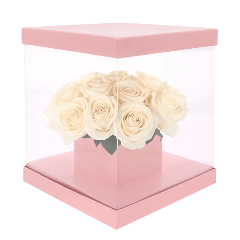 Różowy kwadratowy flower box 25x25 cm z przezroczystymi ściankami wypełniony jasnymi różami. Idealny do efektownej ekspozycji kwiatowych kompozycji.