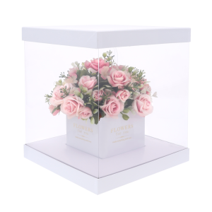 Przezroczysty kwadratowy flower box z bukietem róż wewnątrz. Dzięki dyskretnym otworom w ściance kwiaty zachowują świeżość, prezentując się elegancko jako prezent.