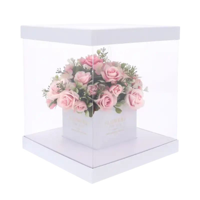 Przezroczysty kwadratowy flower box z bukietem róż wewnątrz. Dzięki dyskretnym otworom w ściance kwiaty zachowują świeżość, prezentując się elegancko jako prezent.