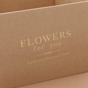 Zbliżenie na nadruk na kraftowym pudełku z napisem Flowers for you wykonany w złotym kolorze.