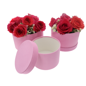 Różowe welurowe flowerboxy z kompozycjami z żywych czerwonych róż. Pudełka stanowią bazę dla florystyki.