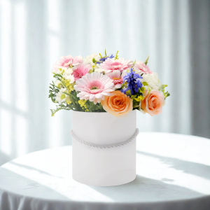 Flower box z kwiatami ustawiony na stole, prezentujący sposób wykorzystania pudełka w aranżacji wnętrz.