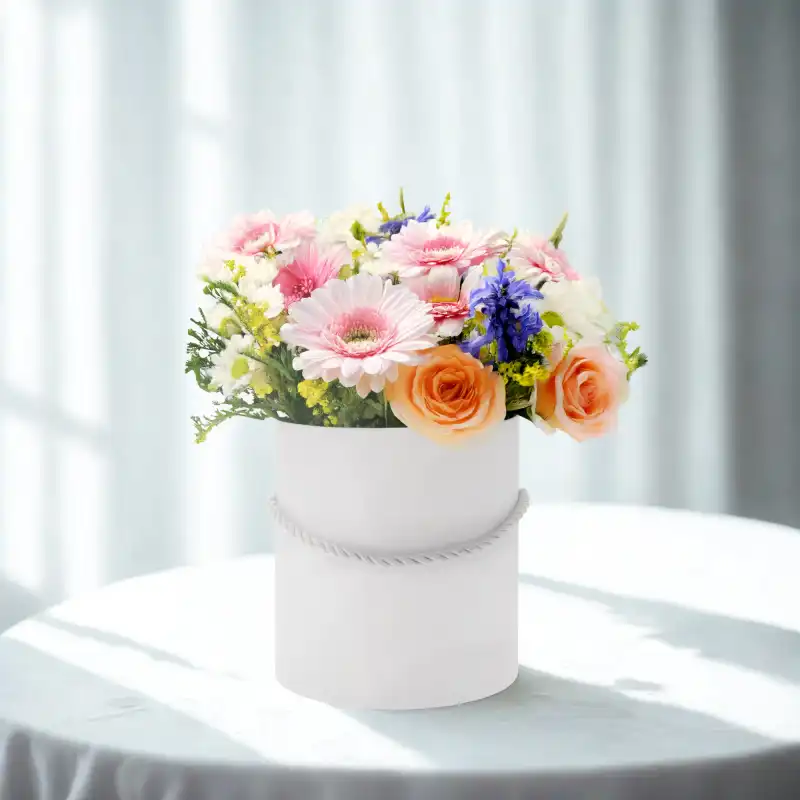 Flower box z kwiatami ustawiony na stole, prezentujący sposób wykorzystania pudełka w aranżacji wnętrz.