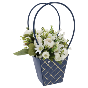 Granatowa torebka na kwiaty 33 cm wypełniona jasną kompozycją roślinną. Widoczne zestawienie kontrastowych kolorów kwiatów z eleganckim pikowanym wykończeniem.