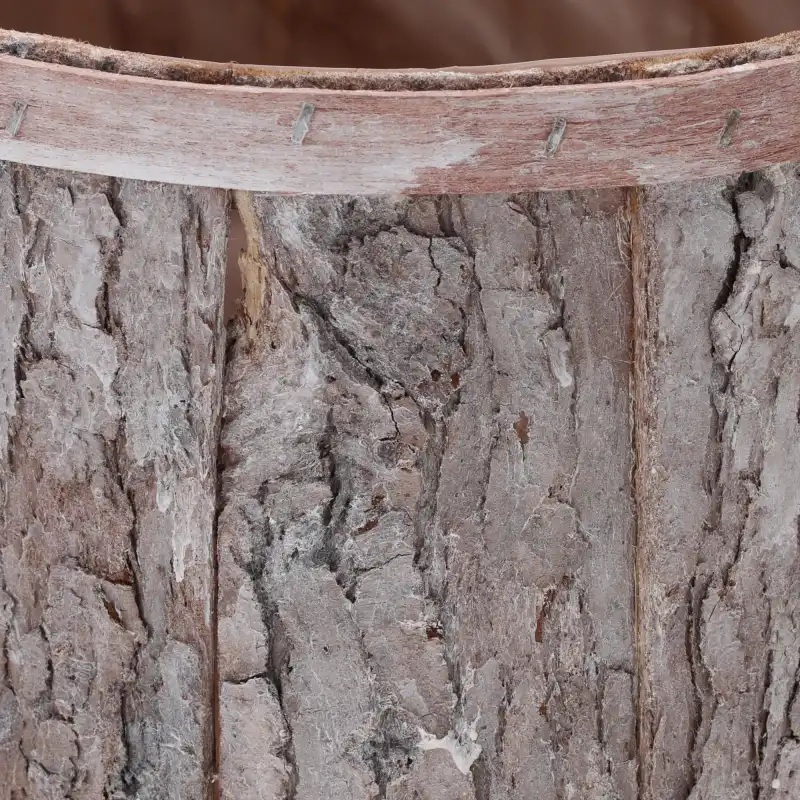 Zbliżenie na naturalną fakturę kory, z której wykonano osłonkę. Widoczny detal łączenia i surowa powierzchnia drewna nadająca wnętrzu ciepły klimat.