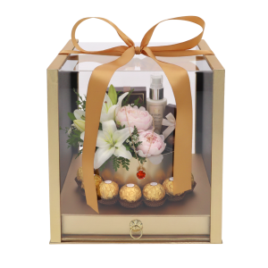 Przykładowa aranżacja flower boxa z kwiatami, biżuterią i słodyczami. Widoczna zawartość w przezroczystym pudełku.