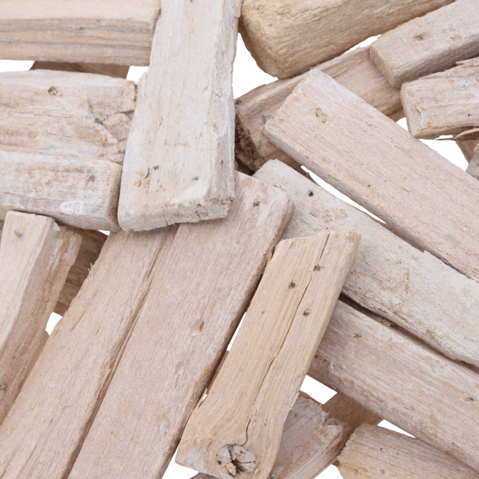 Zbliżenie na fakturę naturalnego drewna, z którego stworzono ażurową konstrukcję dekoracyjnej gwiazdy, podkreślające surowy charakter ozdoby.