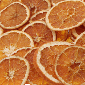 Zbliżenie na teksturę naturalnie suszonych plastrów pomarańczy. Wyraźnie widoczne detale miąższu i skórki wykorzystywane jako materiał florystyczny.