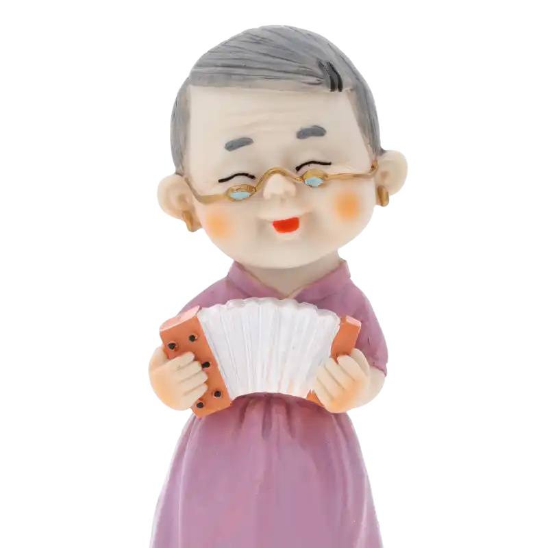 Frontalne ujęcie figurki babci z harmonią w skali 15 cm. Wyraźny rysunek twarzy i szczegółowe wykończenie elementu dekoracyjnego.