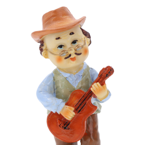 Zbliżenie na figurkę dziadka w kapeluszu i okularach, który trzyma w dłoniach drewnianą gitarę. Widoczne detale stroju.