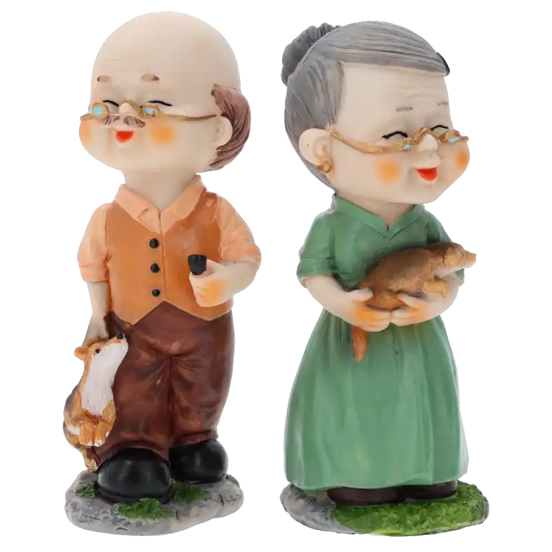 Dwie figurki z tworzywa przedstawiające seniorów. Dziadek w kamizelce z fajką, babcia w zielonej sukience trzymająca zwierzątko.