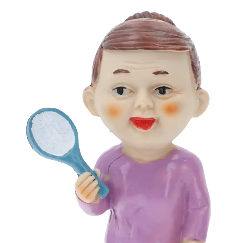 Portretowe ujęcie figurki babci z paletką. Widoczne szczegóły wyrazu twarzy oraz sposób trzymania akcesorium sportowego.