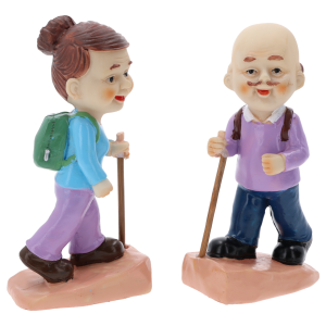Zbliżenie na figurki babci i dziadka ustawione profilem. Widać detale plecaków oraz kije do nordic walking, wykonane z tworzywa.