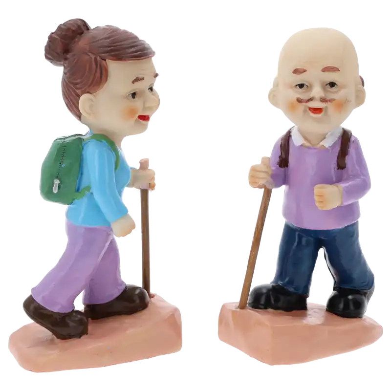 Zbliżenie na figurki babci i dziadka ustawione profilem. Widać detale plecaków oraz kije do nordic walking, wykonane z tworzywa.