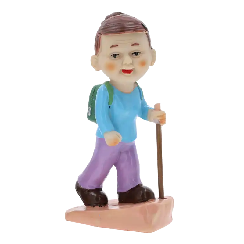 Figurka babcia turystka o wysokości 16 cm, wykonana z tworzywa, przedstawia postać wędrującą z plecakiem i kijkiem trekkingowym.