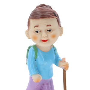 Zbliżenie na twarz figurki babci turystki, ukazujące szczegółowe malowanie postaci z plecakiem i kijkiem.