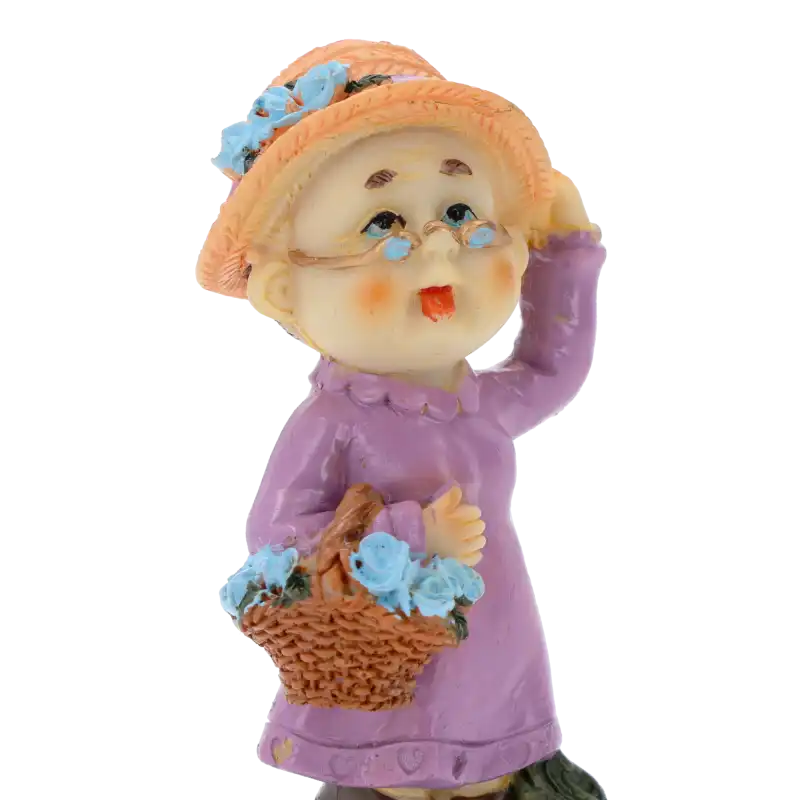 Prezentacja detali figurki babci z kwiatami. Widać precyzyjnie wykonane okulary i nakrycie głowy. Dekoracja z tworzywa o wysokości 10 cm.