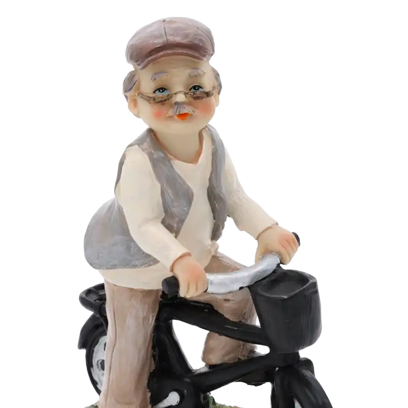 Portretowe ujęcie figurki dziadka na rowerze skupiające się na górnej części postaci oraz elementach roweru z tworzywa.