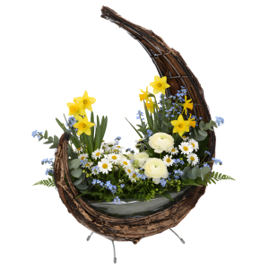 Pozłacany kosz z kory wypełniony wiosenną kompozycją z żółtych żonkili, białych jaskrów i margerytek. Naturalna oprawa florystyczna.