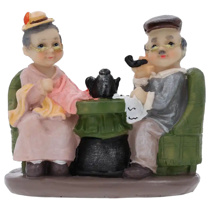 Dekoracyjne figurki babcia i dziadek o wysokości 13 cm, przedstawiające parę seniorów przy stoliku. Idealne jako ozdoba na tort lub element rodzinnego stroika domowego.