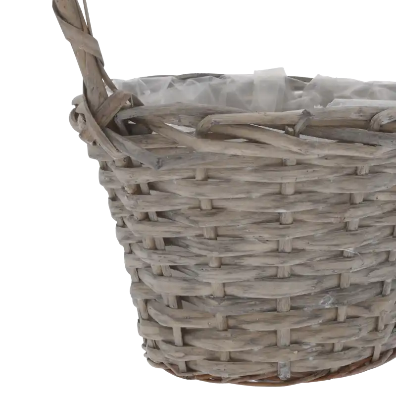 Zbliżenie na splot naturalnej wikliny w kolorze brązowym, widoczny łączenie rączki z korpusem koszyka.