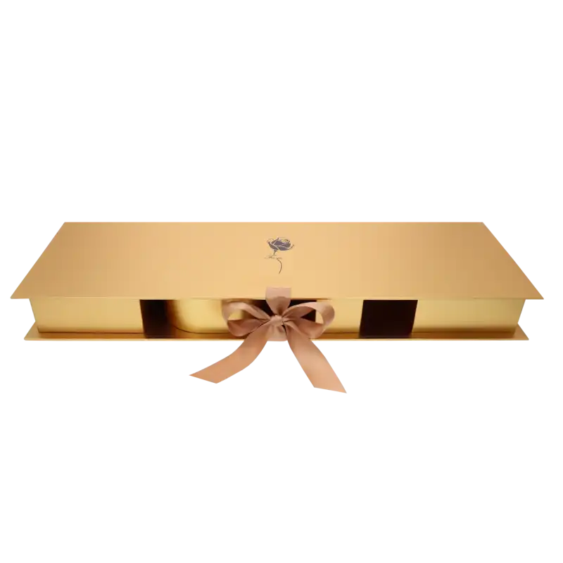 Zamknięty złoty flowerbox z satynową wstążką i nadrukiem róży. Pudełko prezentuje się elegancko i nowocześnie.