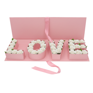 Kompozycja kwiatowa umieszczona w różowym flowerboxie z literami LOVE, prezentująca gotowy pomysł na prezent.