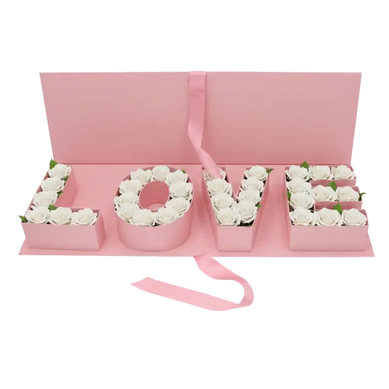 Kompozycja kwiatowa umieszczona w różowym flowerboxie z literami LOVE, prezentująca gotowy pomysł na prezent.