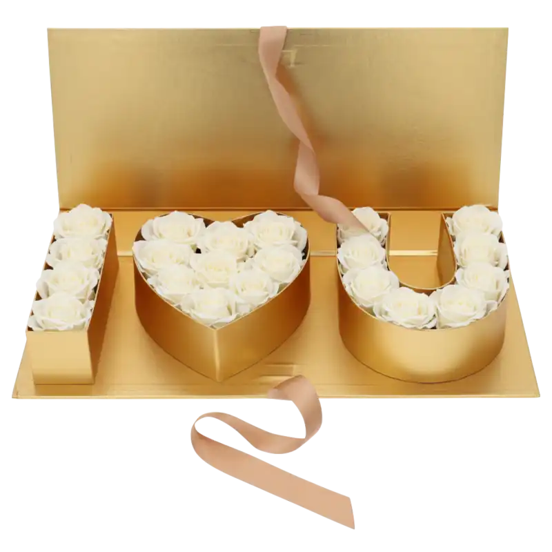 Złoty flowerbox wypełniony białymi różami, tworzący napis I love you. Luksusowa kompozycja prezentowa z satynową wstążką.