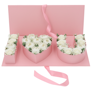 Różowy flowerbox o szerokości 45 cm wypełniony białymi różami, tworzącymi napis I love you wewnątrz pudełka.