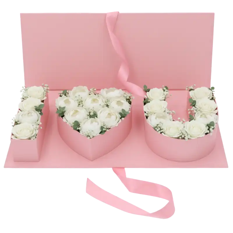 Różowy flowerbox o szerokości 45 cm wypełniony białymi różami, tworzącymi napis I love you wewnątrz pudełka.