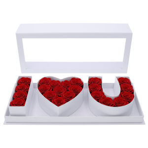 Przykładowa aranżacja flowerboxa z żywymi czerwonymi różami ułożonymi w litery napisu I♡U. Przezroczysta pokrywka chroni i eksponuje kompozycję kwiatową w białym kartonowym pudełku.