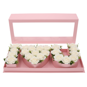 Różowy flowerbox 45 cm wypełniony białymi różami, tworzącymi napis I♡U. Przezroczysta pokrywka podkreśla estetyczny wygląd kompozycji kwiatowej w tym nowoczesnym pudełku.