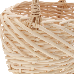 Zbliżenie na miejsce mocowania rączki do owalnego kosza wiklinowego, prezentujące sposób wyplotu naturalnego materiału.