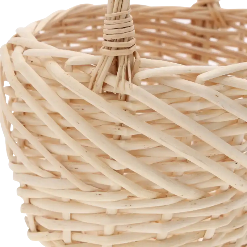 Zbliżenie na miejsce mocowania rączki do owalnego kosza wiklinowego, prezentujące sposób wyplotu naturalnego materiału.