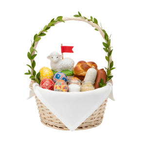 Wiklinowy koszyk wypełniony wielkanocnymi produktami: pisankami, barankiem z flagą, wędlinami i babką. Naturalna dekoracja świątecznego stołu.
