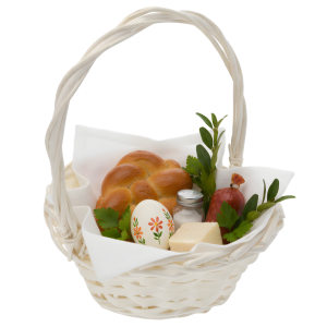 Naturalny kosz wiklinowy wypełniony świątecznymi produktami, gotowy jako elegancki zestaw prezentowy na Wielkanoc.