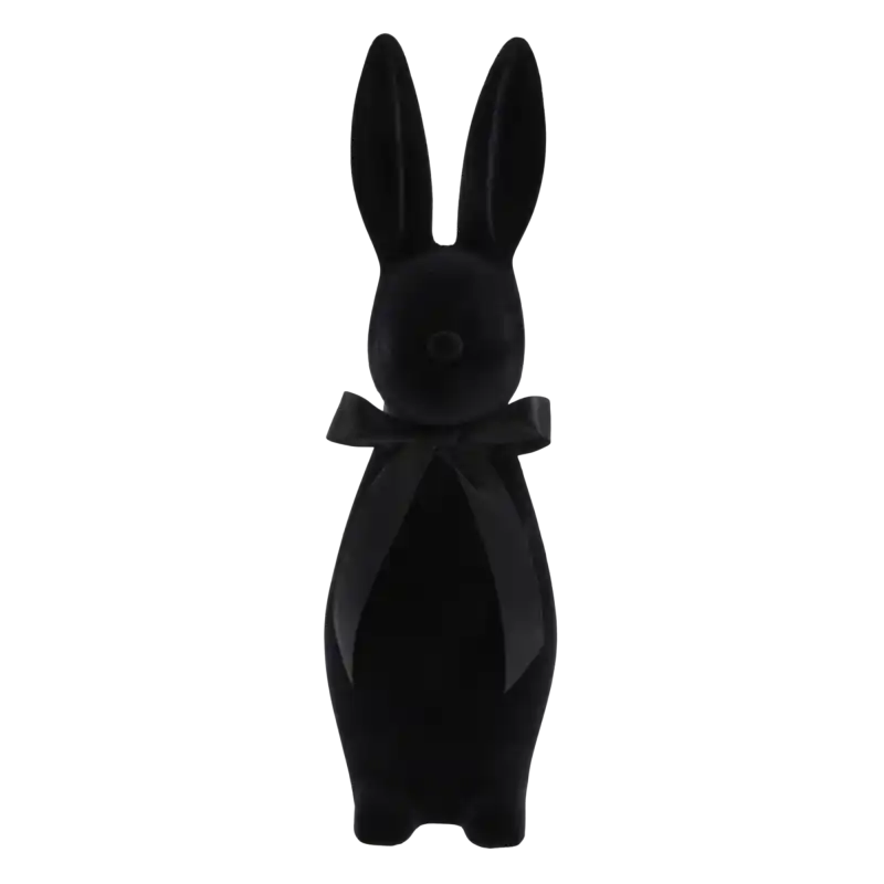 Czarny welurowy zając o wysokości 47 cm z elegancką satynową kokardą na szyi. Nowoczesna dekoracja wielkanocna o flokowanej, miękkiej powierzchni, która stanowi wyrazisty akcent w każdym wnętrzu.