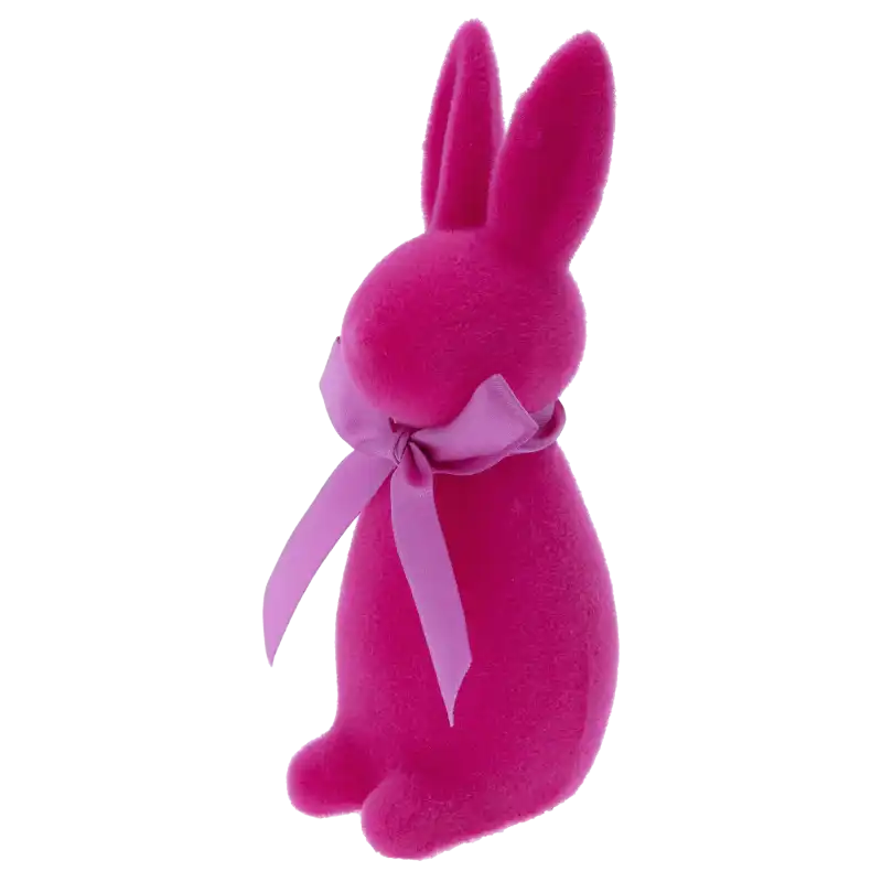 Ujęcie figurki zająca wielkanocnego z perspektywy lewego profilu. Miękka, flokowana powierzchnia w kolorze fuksji prezentuje się nowocześnie i elegancko.