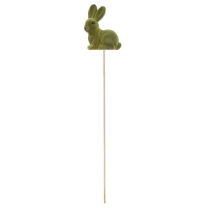 Widok z profilu na zielonego flokowanego zająca na długim drewnianym patyczku o łącznej długości 50 cm. Figurka ma 10 cm wysokości.